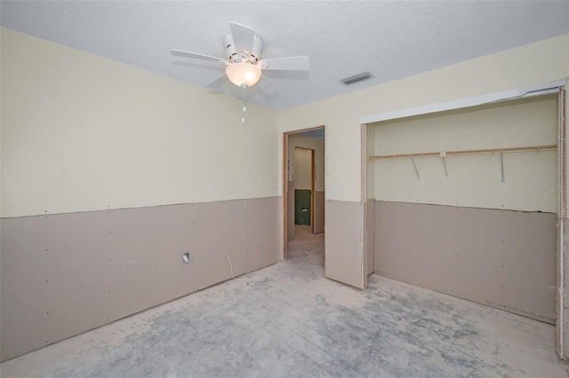 unfurnished bedroom featuring visible vents, a textured ceiling, a closet, and ceiling fan