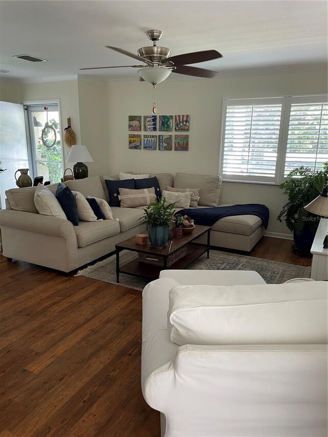 living room featuring a ceiling fan, wood finished floors, visible vents, and ornamental molding