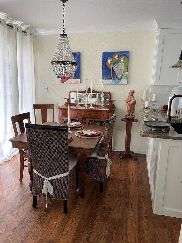 dining space featuring crown molding, baseboards, and wood finished floors