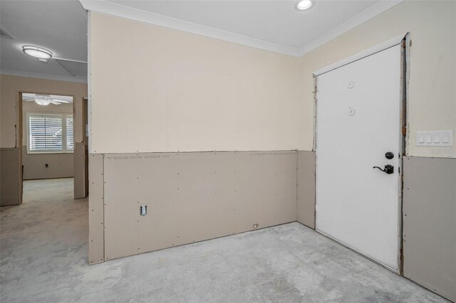 empty room featuring crown molding and concrete floors