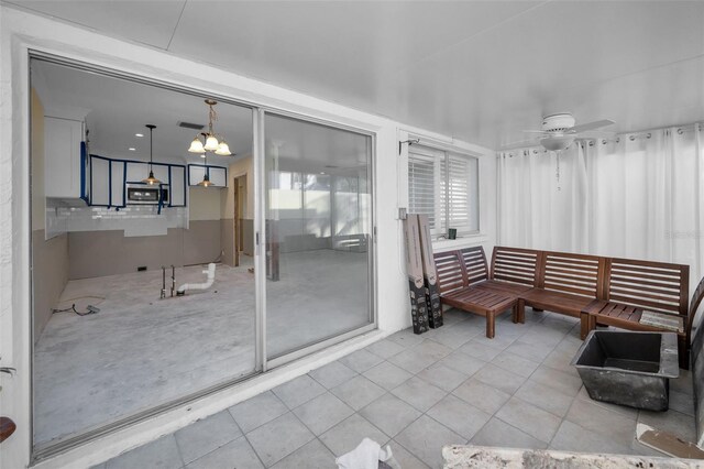 interior space with visible vents and ceiling fan with notable chandelier