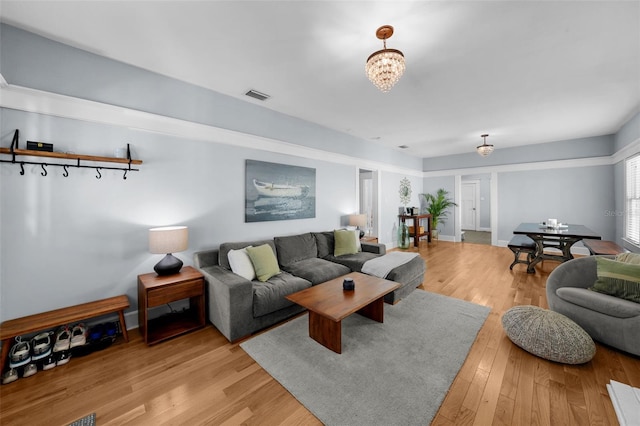 living room featuring light hardwood / wood-style flooring and a notable chandelier