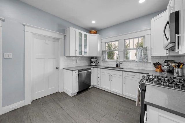 kitchen featuring white cabinetry, stainless steel appliances, sink, and backsplash