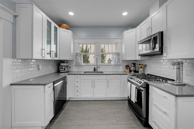 kitchen with white cabinetry, sink, backsplash, and appliances with stainless steel finishes