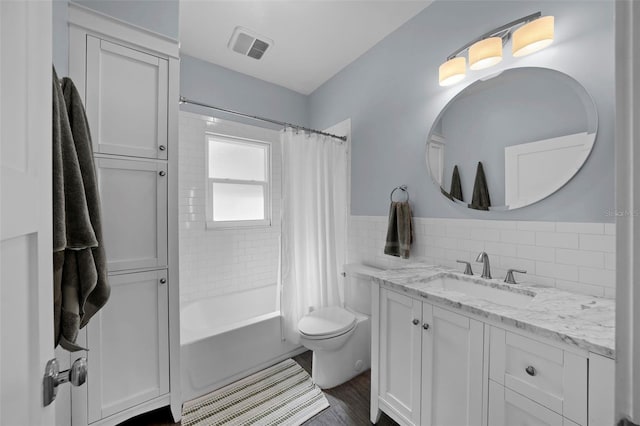 full bathroom with toilet, wood-type flooring, tile walls, vanity, and shower / bath combo with shower curtain