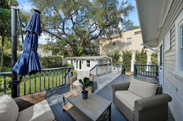 wooden deck featuring a yard, an outdoor structure, and a garage