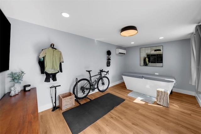 bathroom featuring wood-type flooring and a wall mounted air conditioner