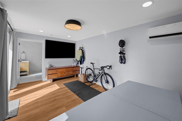 exercise room featuring light hardwood / wood-style flooring and a wall mounted AC