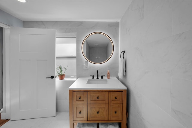 bathroom featuring vanity and tile walls