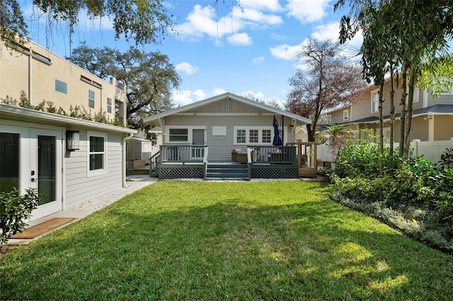 rear view of house featuring a yard and a deck