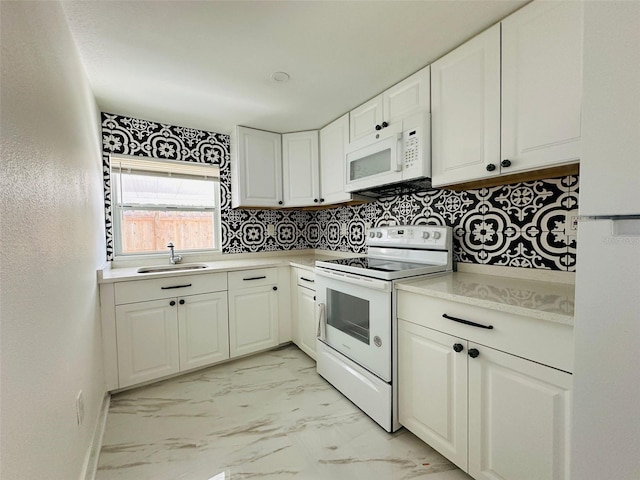 kitchen featuring white cabinetry, sink, and white appliances