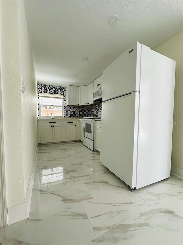 kitchen featuring tasteful backsplash, white appliances, and a textured ceiling