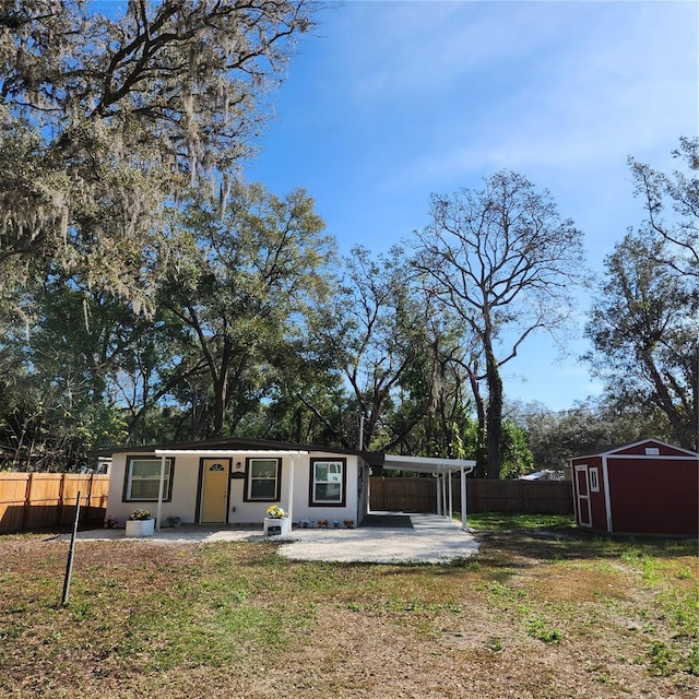 exterior space featuring a patio, a lawn, and a storage unit