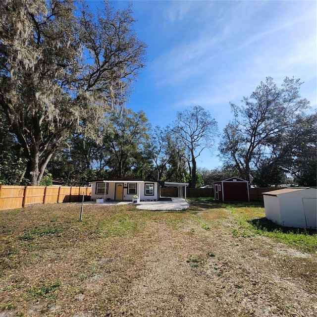 view of yard featuring a storage shed and a patio