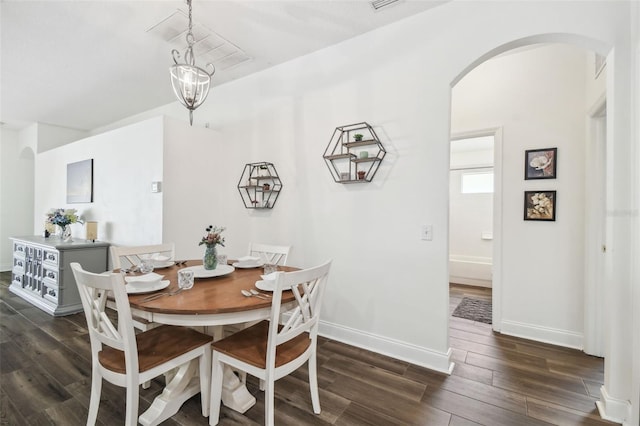 dining area with dark hardwood / wood-style floors and a notable chandelier