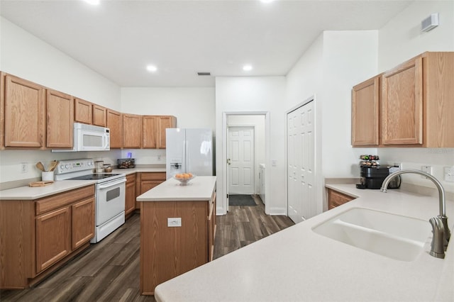 kitchen with white appliances, dark hardwood / wood-style flooring, sink, and a kitchen island