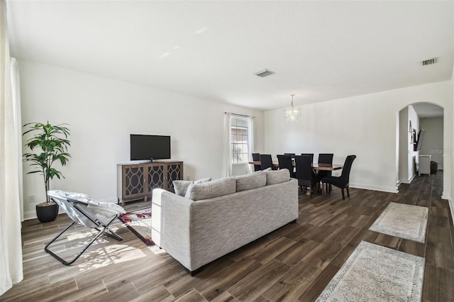 living room with dark hardwood / wood-style flooring and a chandelier