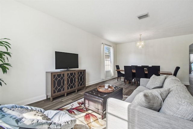 living room featuring an inviting chandelier and dark hardwood / wood-style floors