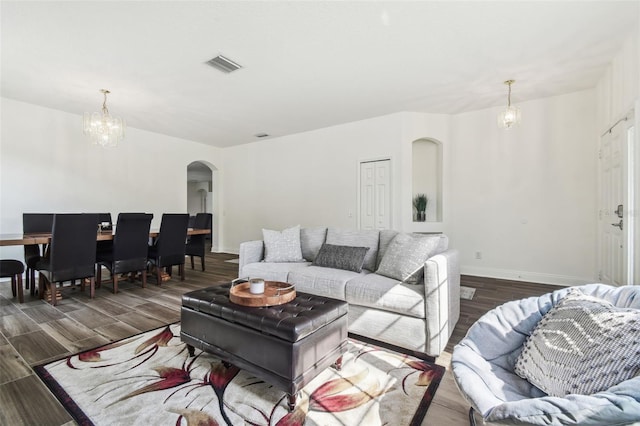 living room with dark hardwood / wood-style flooring and a chandelier