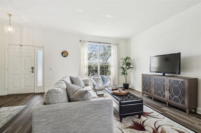 living room featuring dark hardwood / wood-style floors, an inviting chandelier, and a textured ceiling