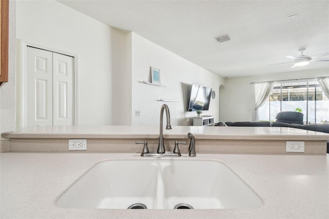 kitchen featuring ceiling fan, sink, and a textured ceiling