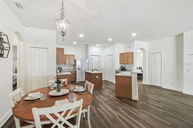 dining space featuring dark wood-type flooring and a chandelier