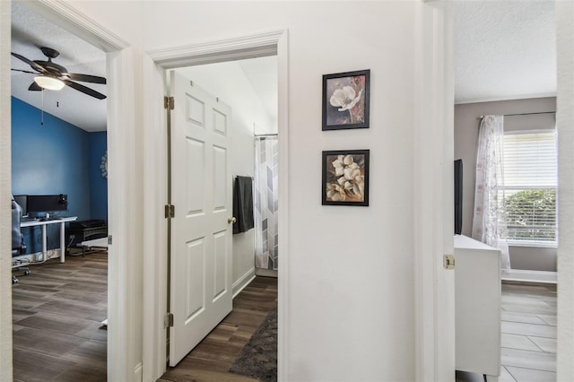 hallway featuring dark hardwood / wood-style floors and a textured ceiling