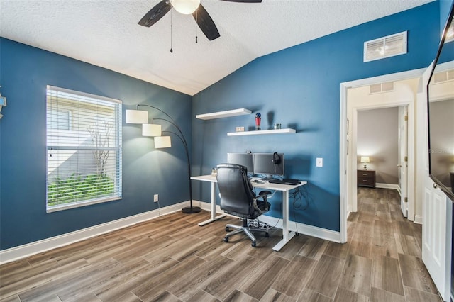 office space featuring ceiling fan, lofted ceiling, hardwood / wood-style floors, and a textured ceiling