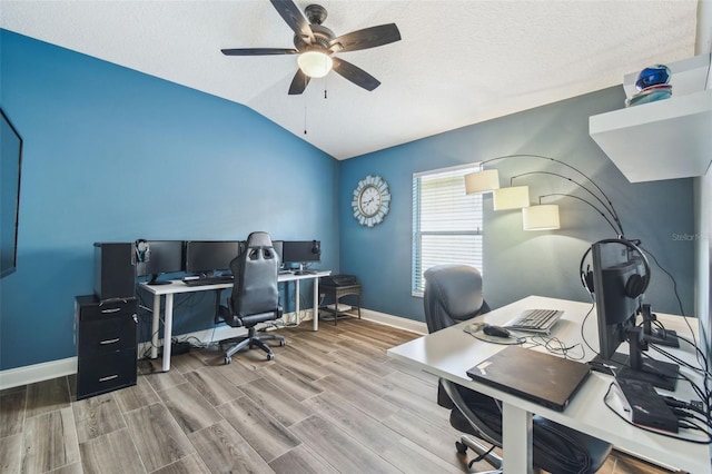 home office with lofted ceiling, hardwood / wood-style floors, a textured ceiling, and ceiling fan