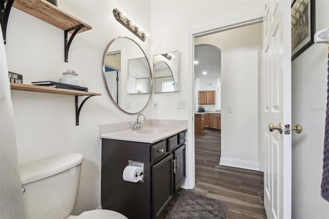 bathroom with hardwood / wood-style flooring, vanity, and toilet