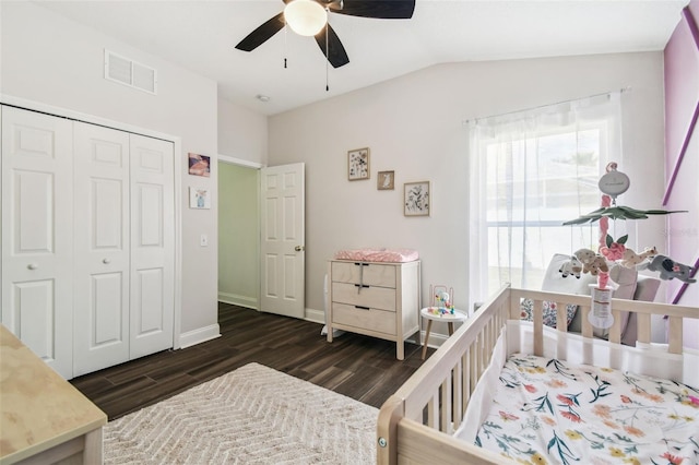 bedroom with ceiling fan, dark hardwood / wood-style floors, vaulted ceiling, and a closet