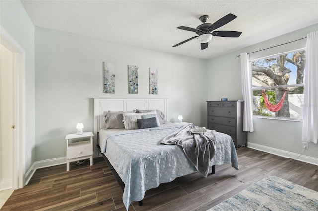 bedroom with dark hardwood / wood-style flooring, ceiling fan, and a textured ceiling