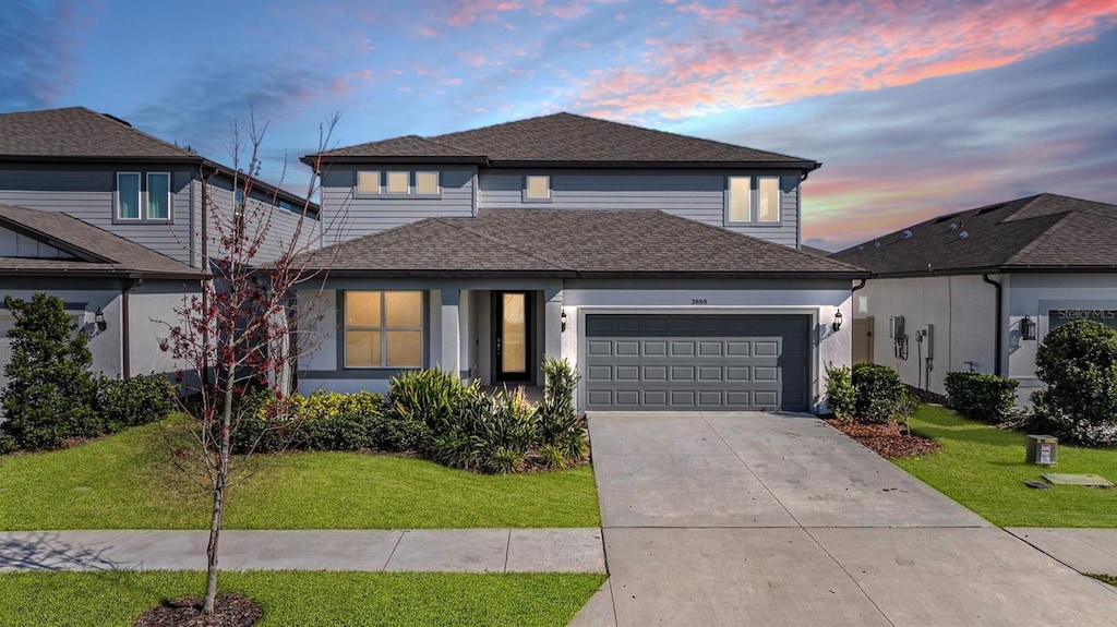 view of front property featuring a garage and a yard