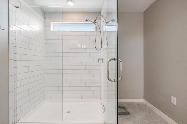 bathroom with an enclosed shower and tile patterned flooring