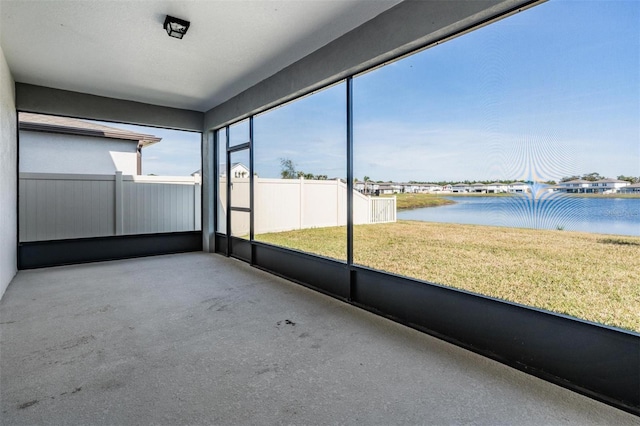 unfurnished sunroom featuring a water view