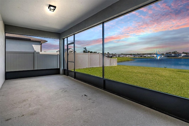 unfurnished sunroom featuring a water view and a wealth of natural light