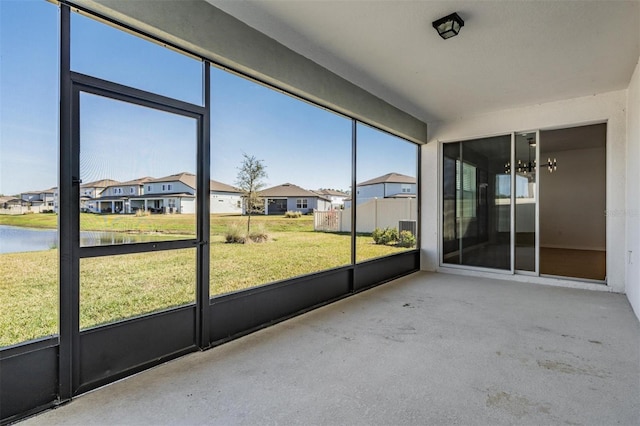 unfurnished sunroom with a water view