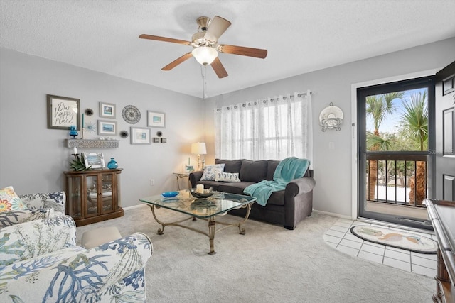 carpeted living room with ceiling fan and a textured ceiling