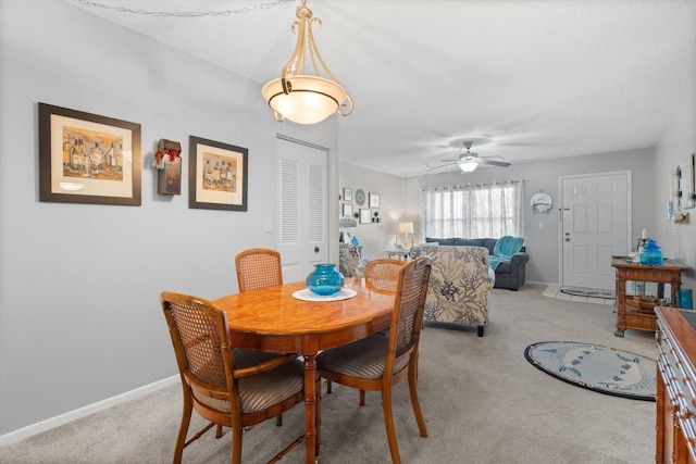 dining area with light colored carpet and ceiling fan