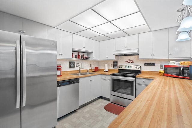 kitchen featuring sink, white cabinetry, stainless steel appliances, wood counters, and decorative light fixtures