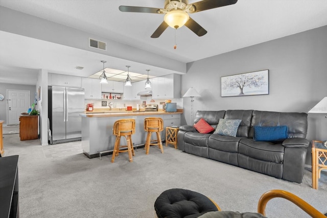 living room featuring light colored carpet and ceiling fan