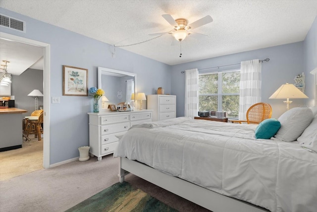 bedroom with ceiling fan, carpet, and a textured ceiling