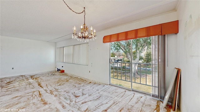 unfurnished dining area with a chandelier and a textured ceiling