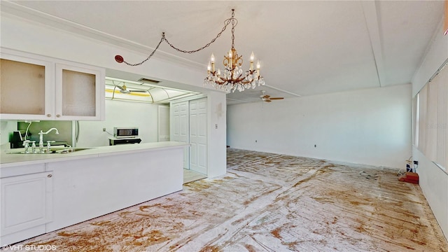 kitchen featuring pendant lighting, sink, white cabinetry, and ceiling fan