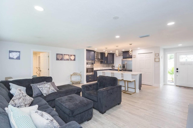 living room with sink and light hardwood / wood-style flooring