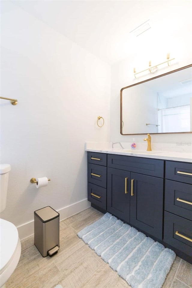 bathroom featuring vanity, hardwood / wood-style floors, and toilet