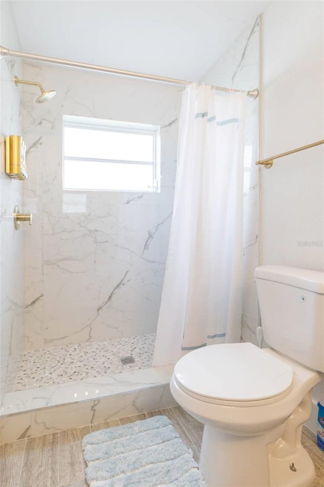 bathroom featuring walk in shower and toilet