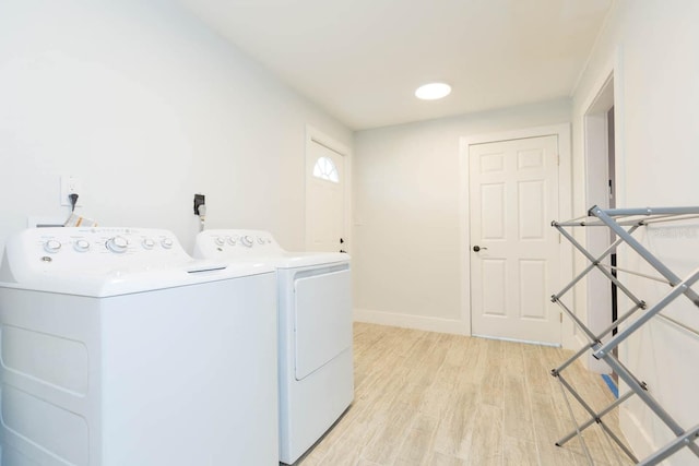 laundry room with independent washer and dryer and light wood-type flooring