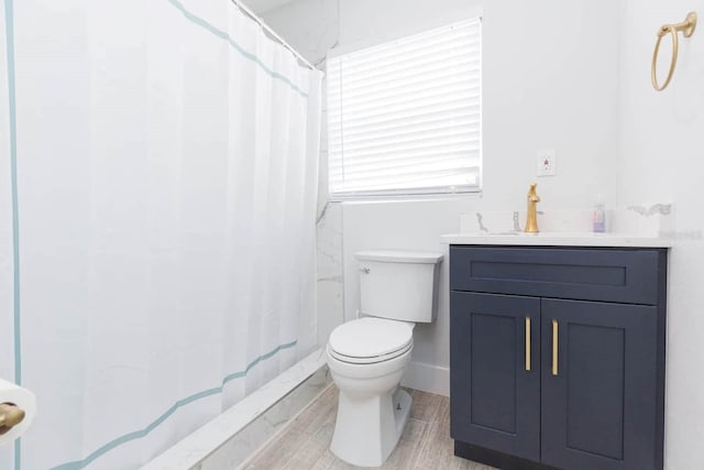 bathroom featuring vanity, toilet, curtained shower, and hardwood / wood-style floors