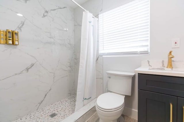 bathroom with vanity, curtained shower, and toilet